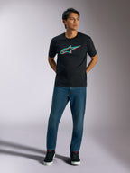 Alpinestars Ageless Shadow CSF Tee, kortærmet T-shirt, sort, turkis og orange Ageless shadow-logo på brystet, båret af model med blå jeans og sorte sko, afslappet motorsport streetwear
