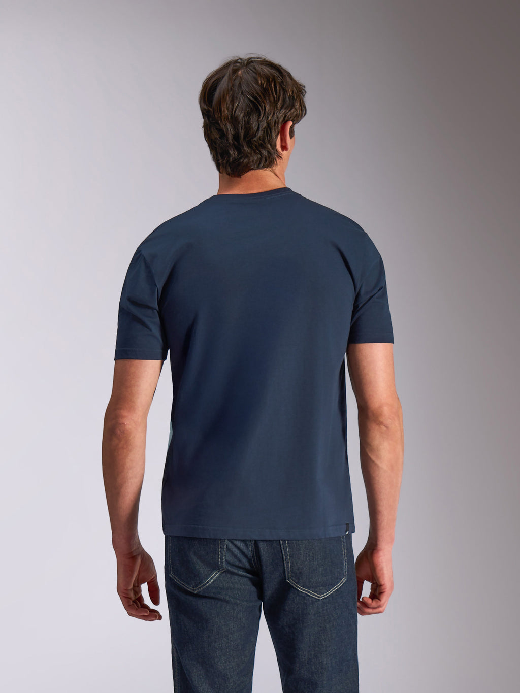 Alpinestars Ageless Shadow CSF Tee, kortærmet T-shirt, marineblå, set bagfra, båret af model med mørk denim, afslappet motorsport-livsstilstøj