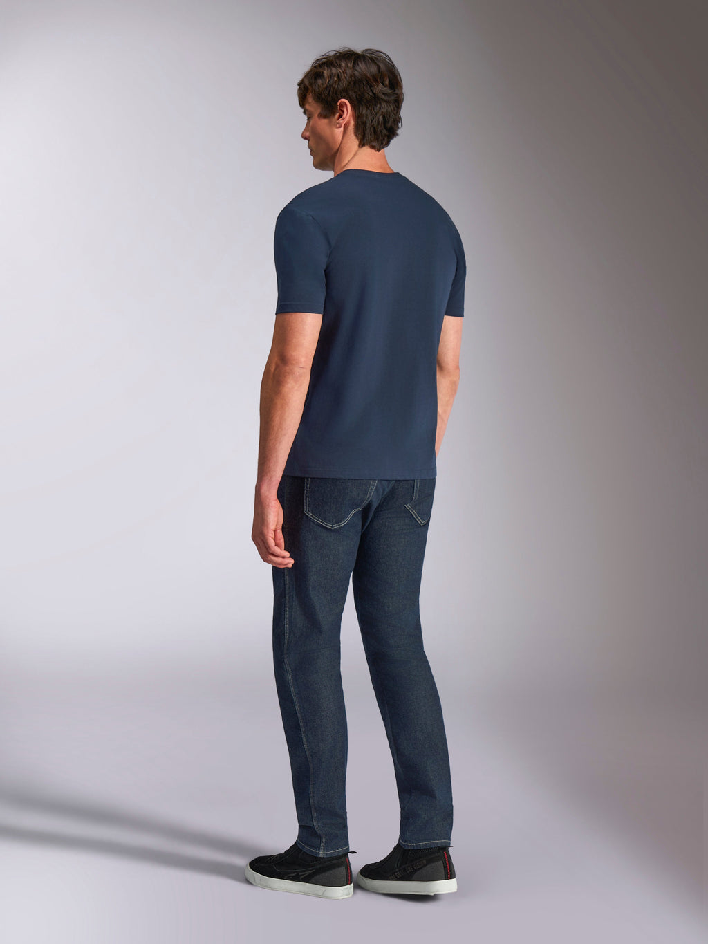 Alpinestars Ageless Shadow CSF Tee, kortærmet T-shirt, navyblå, set bagfra på model, båret med mørke denimjeans og sorte sneakers, casual lifestyle-streetwear
