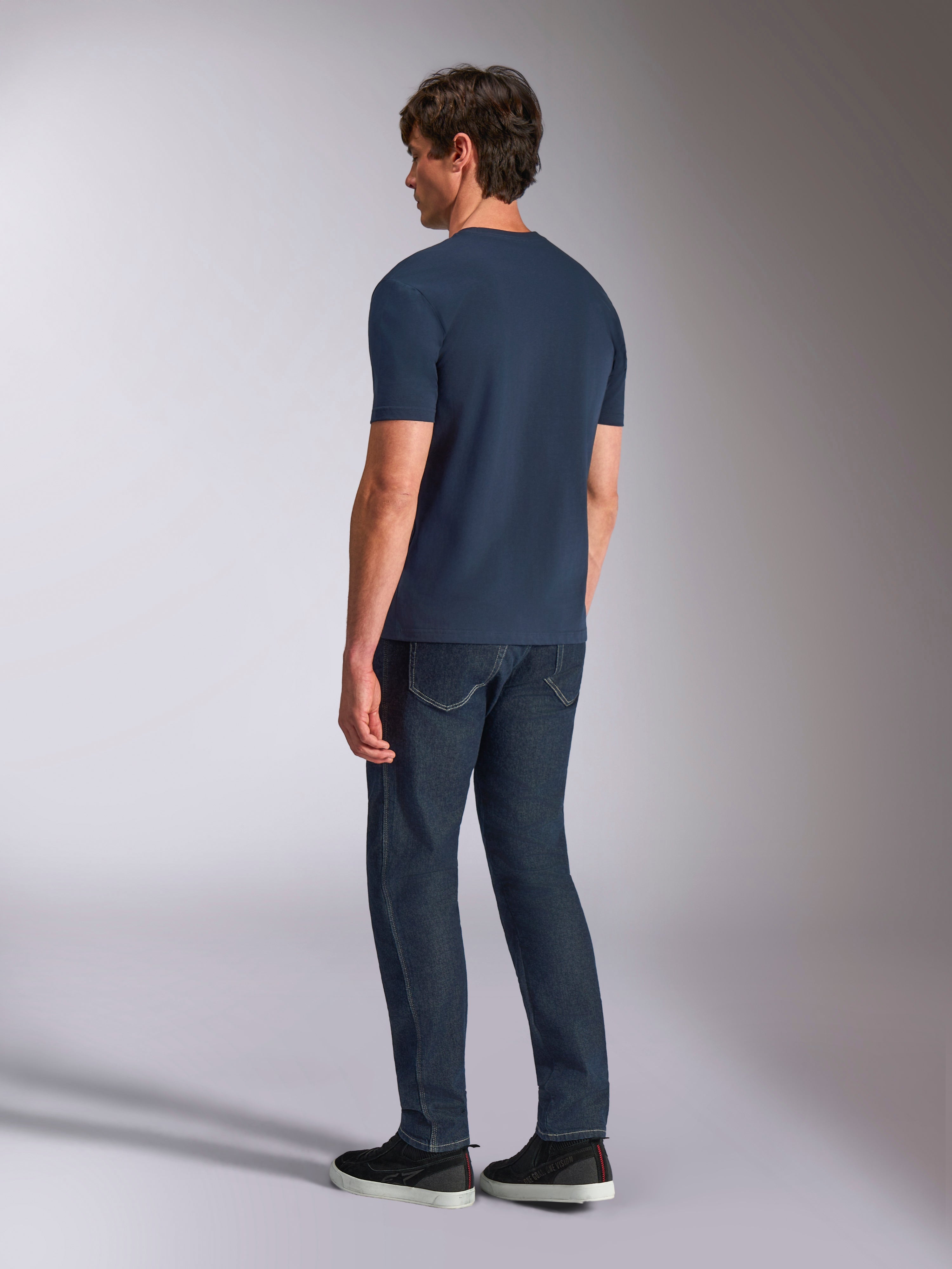 Alpinestars Ageless Shadow CSF Tee, kortærmet T-shirt, navyblå, set bagfra på model, båret med mørke denimjeans og sorte sneakers, casual lifestyle-streetwear