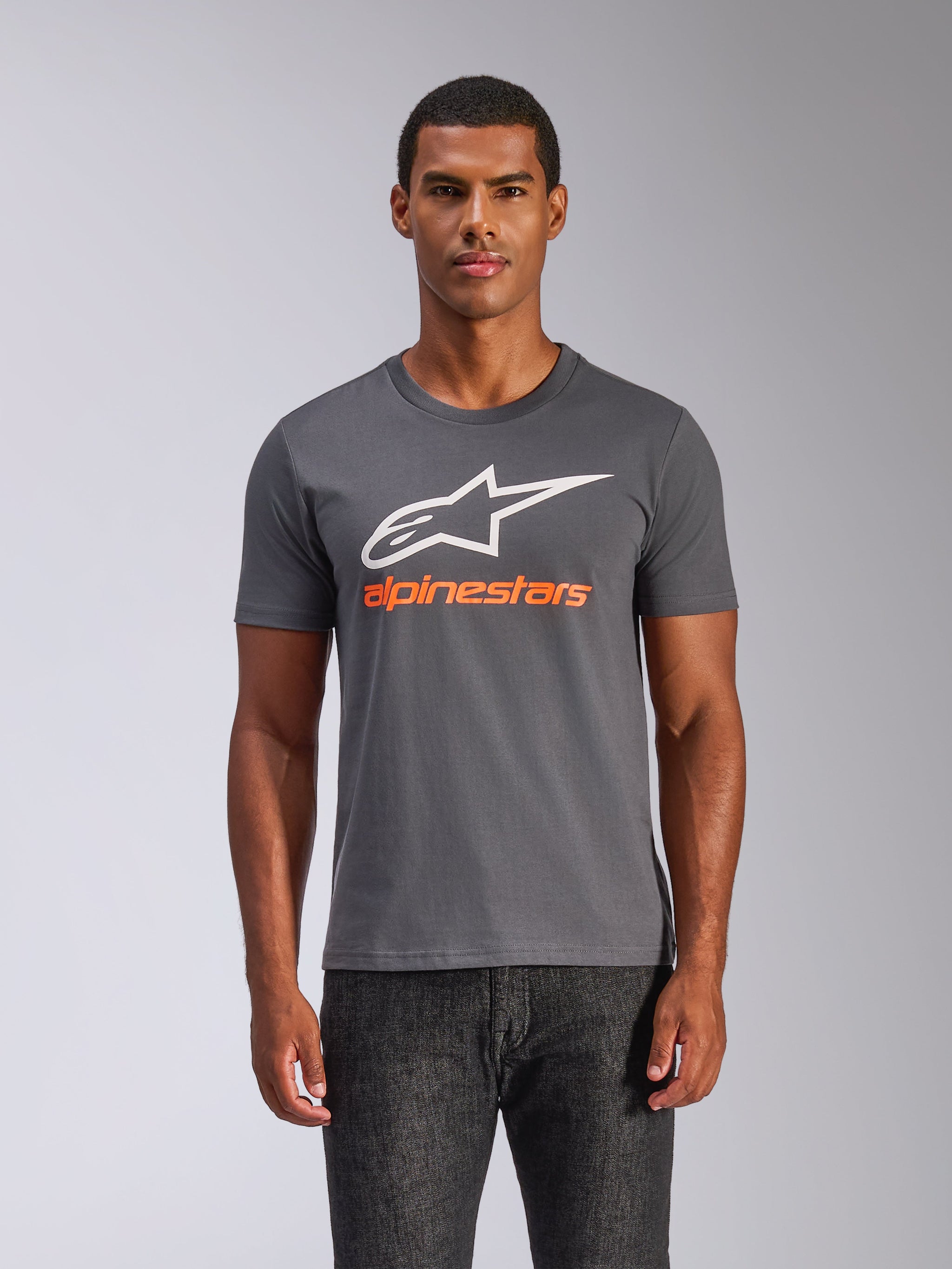 Alpinestars Always 2.0 CSF Tee, kortærmet t-shirt, koksgrå, stort hvidt A-star logo med orange Alpinestars tekstlogo, båret af en mand, casual motorsport streetwear