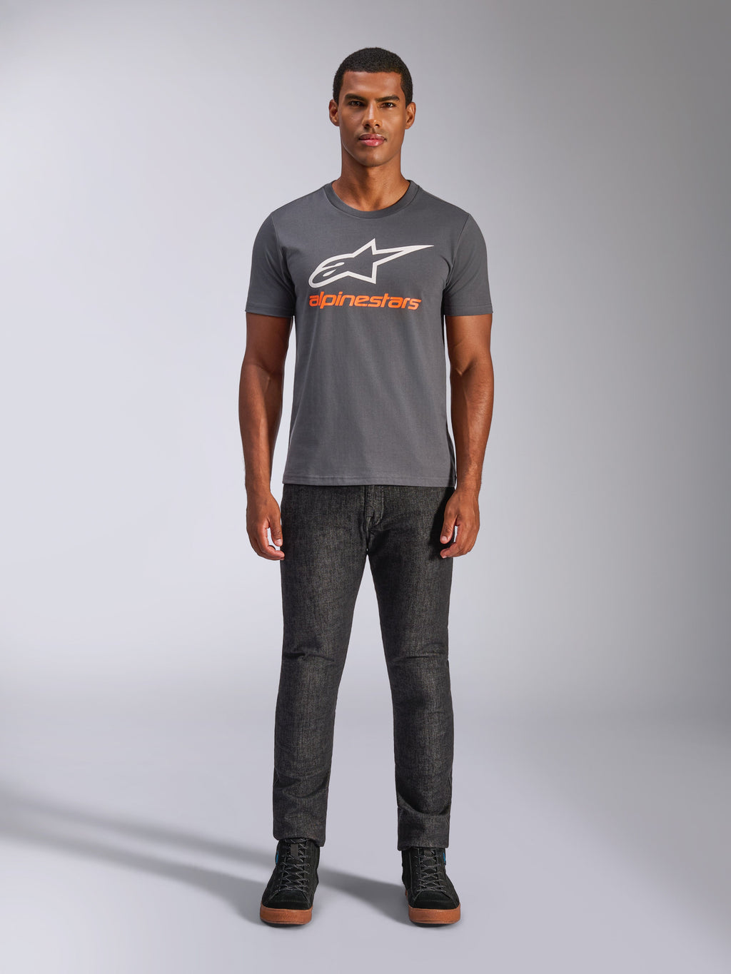 Alpinestars Always 2.0 CSF Tee, kortærmet t-shirt, koksgrå med hvidt logo og orange tekst, båret af model med mørke jeans, afslappet motorsport streetwear