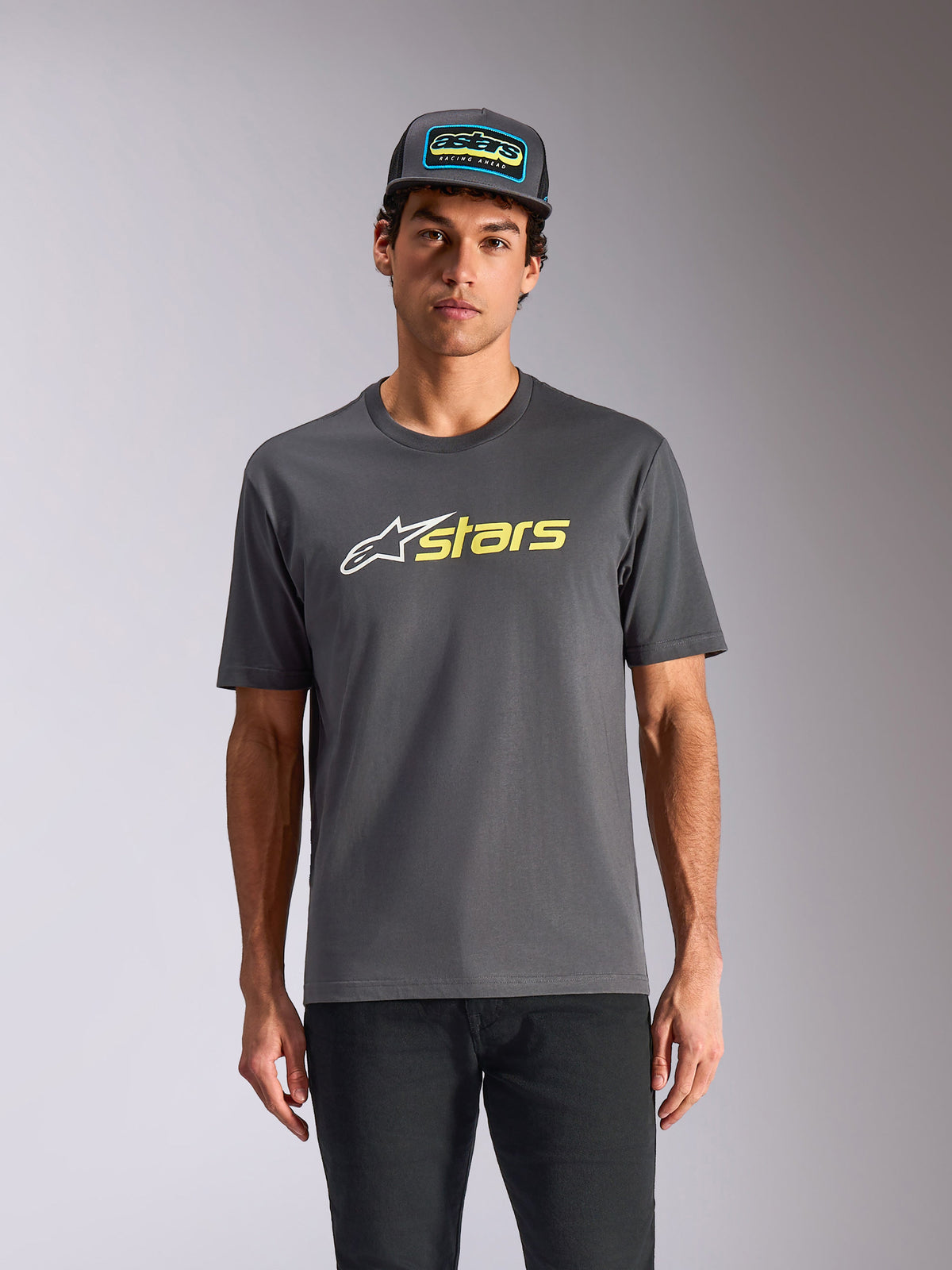 Alpinestars Blaze 2.0 CSF Tee, kortærmet T-shirt, koksgrå, hvidt stjernelogo og Hi-Vis gul stjernegrafik, båret med matchende trucker-hat og sorte bukser, afslappet motorsport streetwear