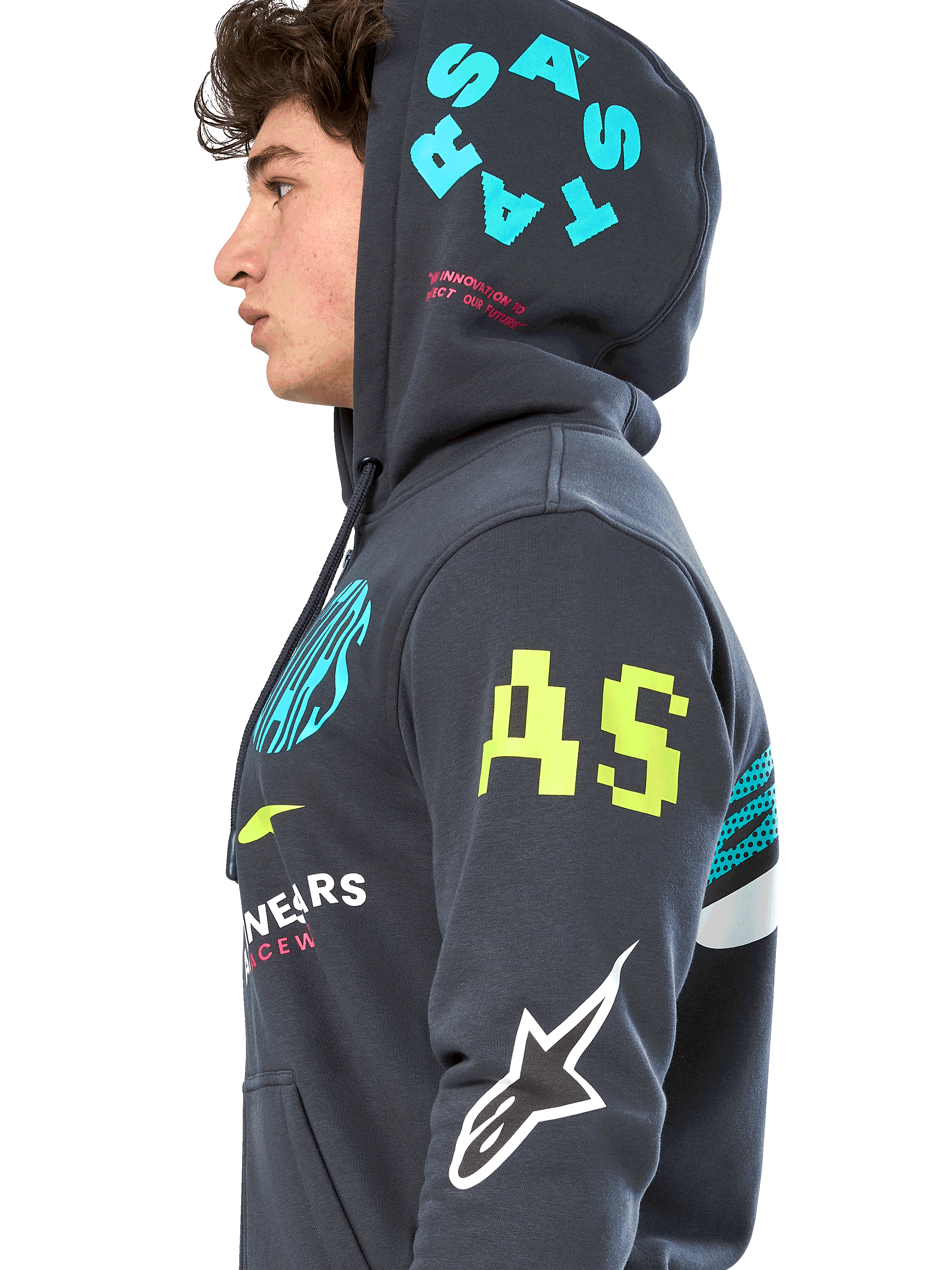 Alpinestars Variegate hættetrøje, gunmetal-grå fleece med lynlås foran, sideprofil af model, multi-logo grafik i neongul, lyseblå og hvid, med 'AS'-branding på ærmet og 'STARS' på hætten, afslappet motorsport-inspireret streetwear
