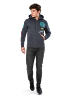 Alpinestars Variegate Hoodie, fleecehættetrøje med lynlås foran, Gunmetal grå, båret af model med sorte jeans og sneakers, med turkis 'ASTARS' branding og farverig logokunst på ærmer og bryst, afslappet motorsport-inspireret streetwear