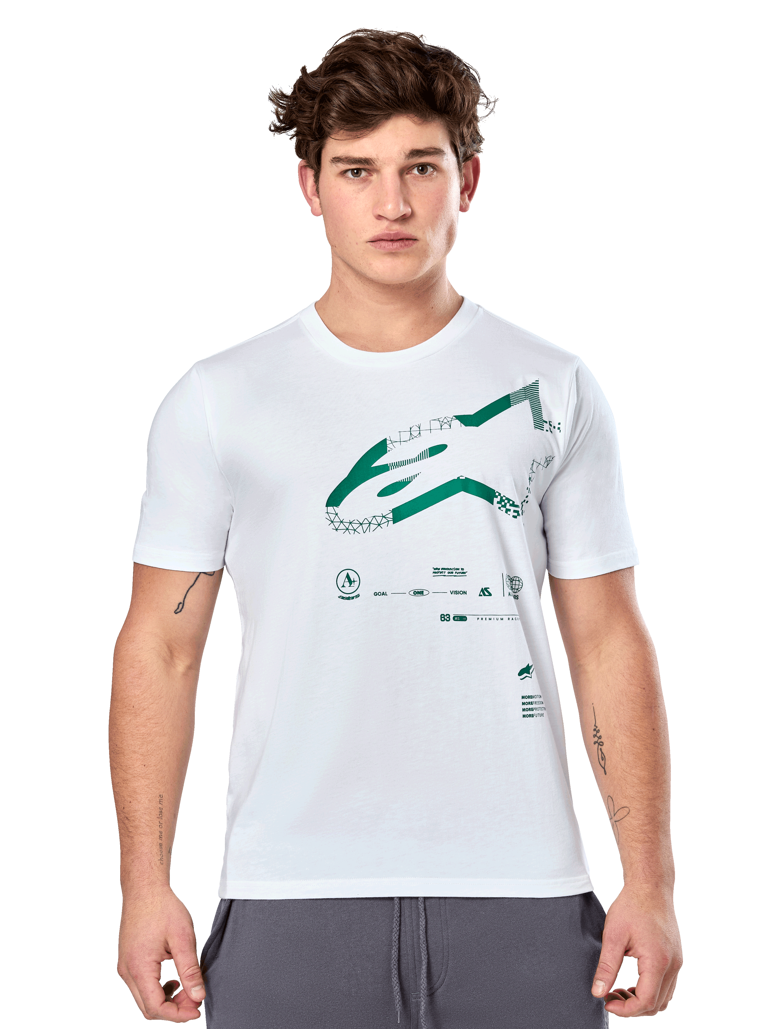 Alpinestars Geografica CSF Tee, hvid kortærmet t-shirt med grøn multi-tech Astars-grafik og tekniske symboler, casual motorsportstøj, mand iført t-shirt og grå bukser mod hvid baggrund