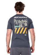 Alpinestars No Barrier Csf Tee, kortærmet t-shirt, charcoal, stort grafik på ryggen med distressed motocross-fotografi og gule diagonale striber, casual motorsportstøj
