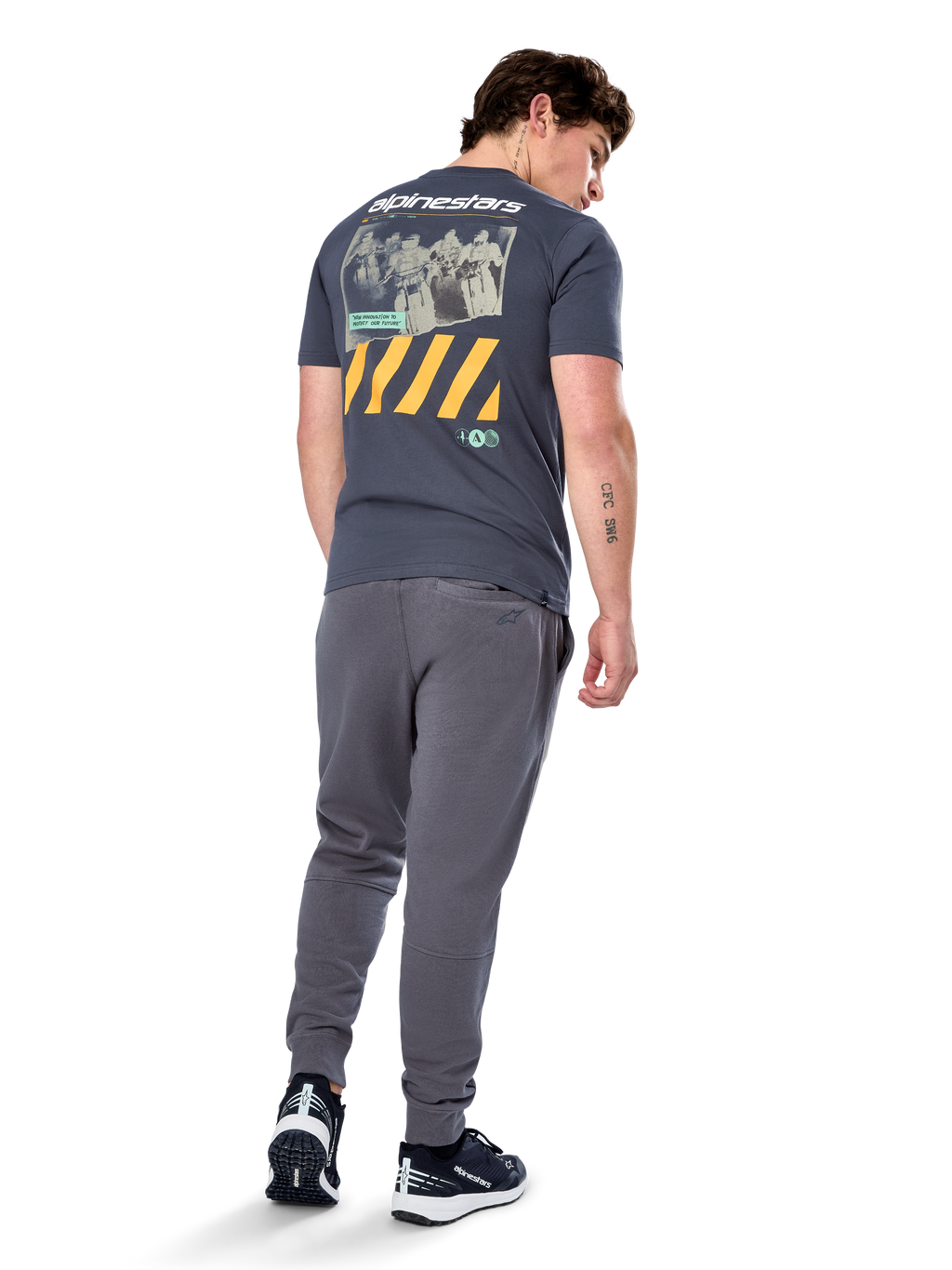 Alpinestars No Barrier CSF Tee, kortærmet t-shirt, koksgrå, set bagfra med stor distressed fotografik med gule diagonale striber og hvidt logo, afslappet motorsport-inspireret streetwear