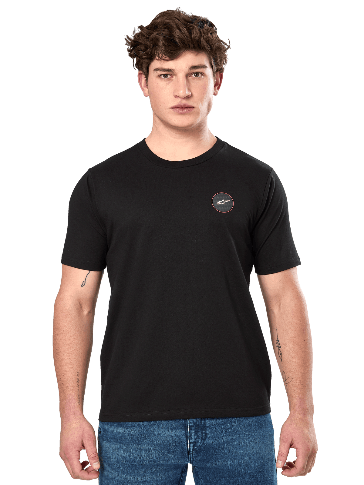 Alpinestars Dot Carbon CSF Tee, kortærmet t-shirt, sort, lille cirkulært brystlogo med hvid Astar og rød kant, båret af en model i blå jeans, casual motorsport-streetwear