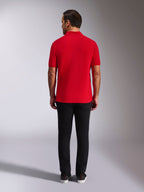 Alpinestars Endeavor Classic Polo, rød piqué-poloshirt, set bagfra, båret med sorte bukser, afslappet motorsport-streetwear med ribkrave og ribkanter på ærmerne
