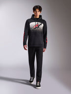 Alpinestars Obsessed hættetrøje, sort pullover-hættetrøje, stort hvidt og rødt Astars-logo med MX-graduering, røde word-logoer på ærmerne, båret af model i et helt sort afslappet outfit, motorsport-inspireret livsstilstøj