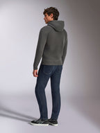 Alpinestars Ellipsoid hættetrøje, afslappet sportstøj, gunmetal-grå, set bagfra på mandlig model, hætte med snøre, lange ærmer, ribstrikkede manchetter og kant forneden, kombineret med mørke jeans og sneakers