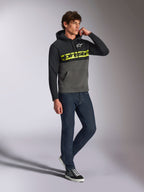 Alpinestars Parallel hættetrøje, afslappet streetwear, farveblokket sort og gunmetal grå, neongult Alpinestars-ordlogo på brystet, hvidt Astars-logo, hætte med snøre, båret med mørke jeans og sneakers