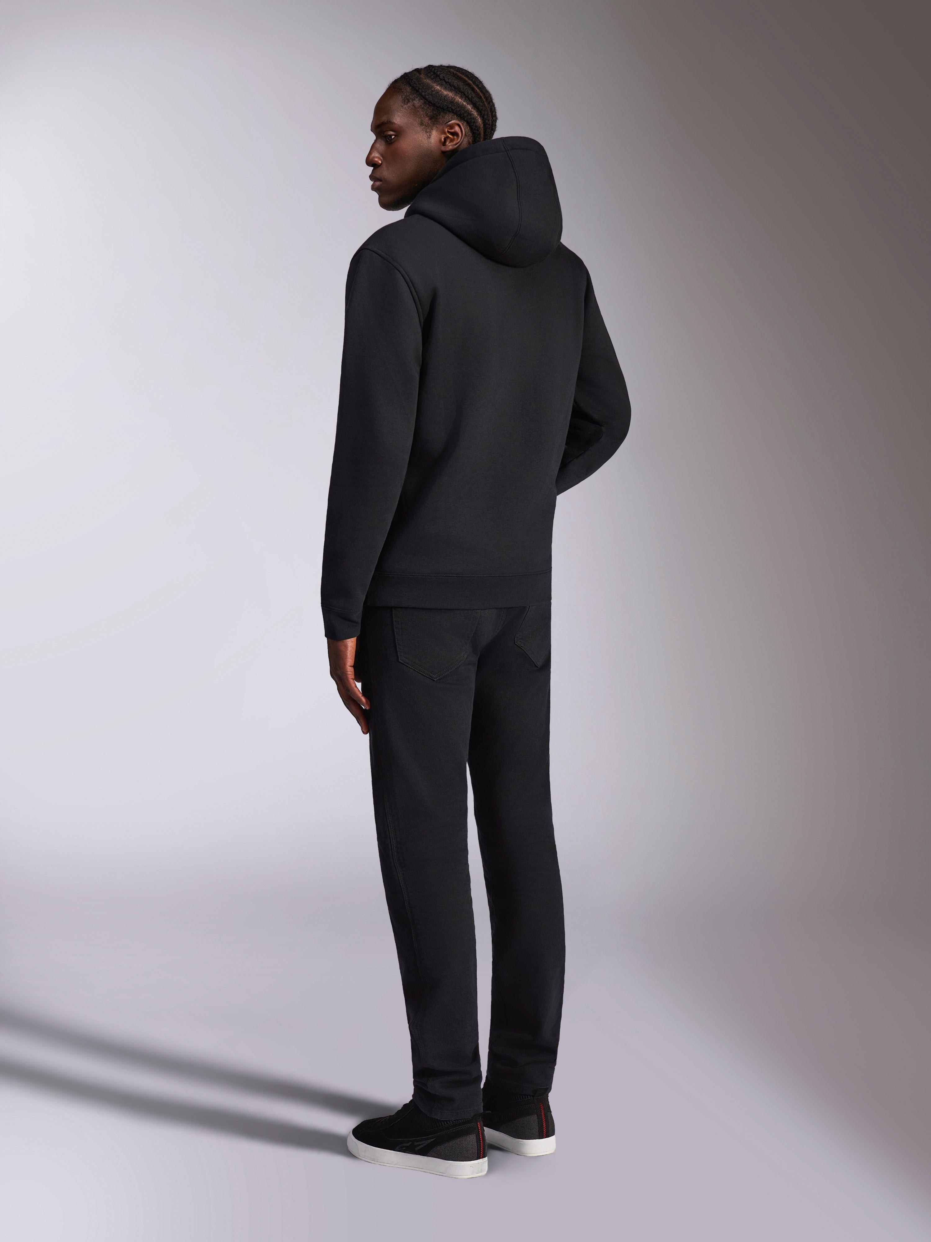 Alpinestars Pulse Hoodie, casual streetwear, sort, model set bagfra iført ensfarvet sort hættetrøje i fleece, minimalistisk design med ribstrikkede manchetter og kant