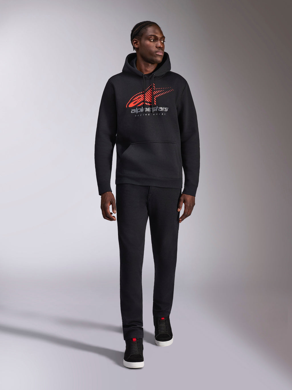 Alpinestars Pulse hættetrøje, sort casual streetwear-hættetrøje, rødt og gråt Astars combo-logo med speed line fade på brystet, hætte med snøre, kængurulomme, lange ærmer, kombineret med sorte bukser og sneakers, motorsport-inspireret design