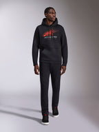 Alpinestars Pulse hættetrøje, sort casual streetwear-hættetrøje, rødt og gråt Astars combo-logo med speed line fade på brystet, hætte med snøre, kængurulomme, lange ærmer, kombineret med sorte bukser og sneakers, motorsport-inspireret design