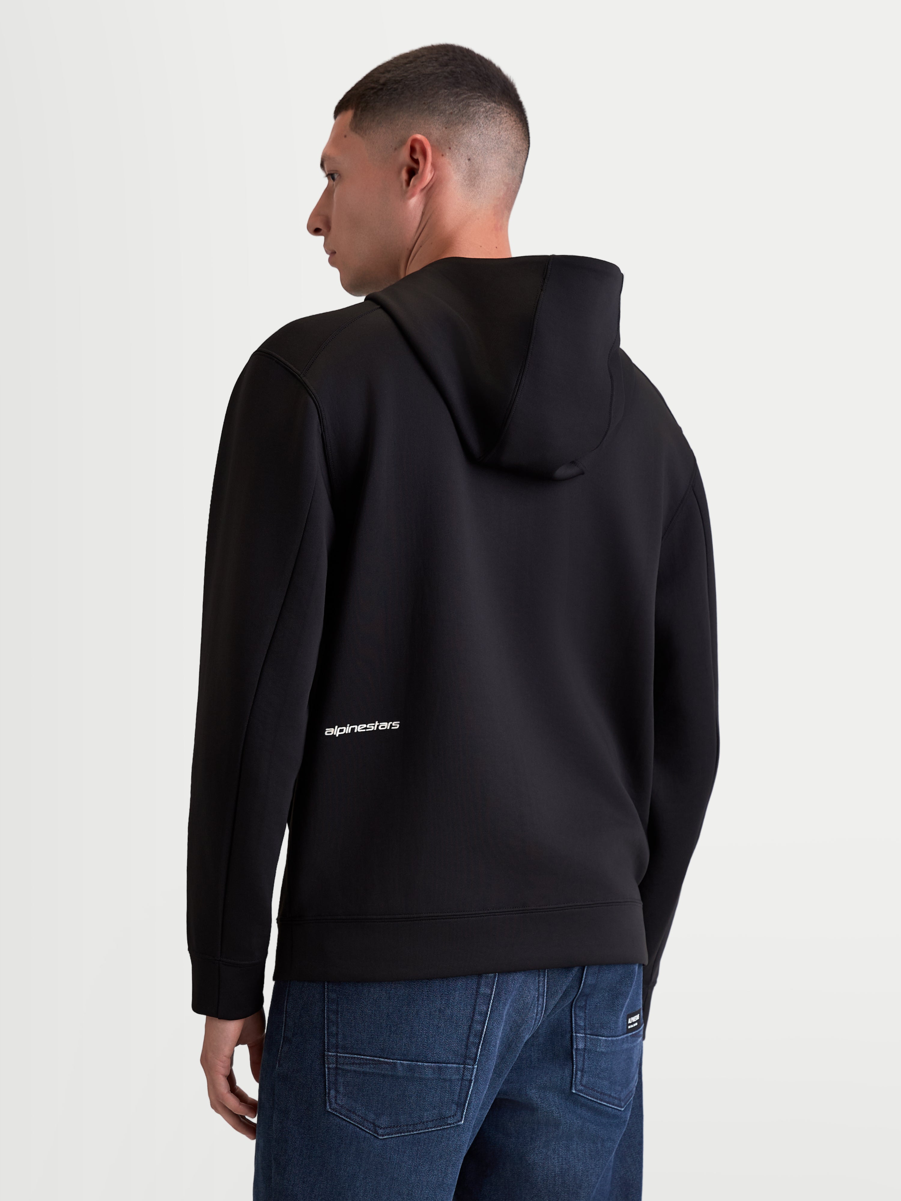 Alpinestars Cypher hættetrøje, herresportstøj lynlåshættetrøje, sort, tri-blend dobbeltsidet fleece, set bagfra på model med høj hætte og hvidt Alpinestars-ordlogo på lænden.