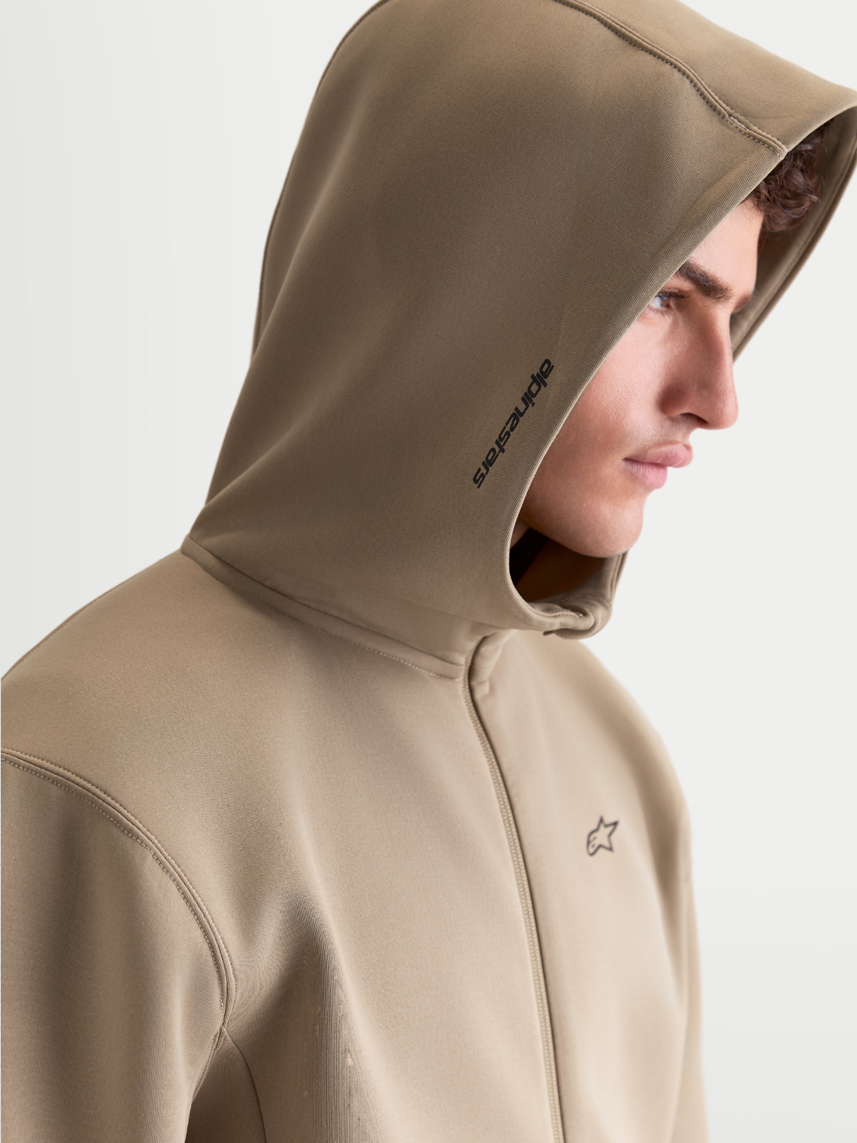 Alpinestars Cypher hættetrøje, herre sportstøj fleecehættetrøje med lynlås, beige, med højhalset mesh-foret hætte, Alpinestars branding på siden og logo på brystet, profilvisning på model.