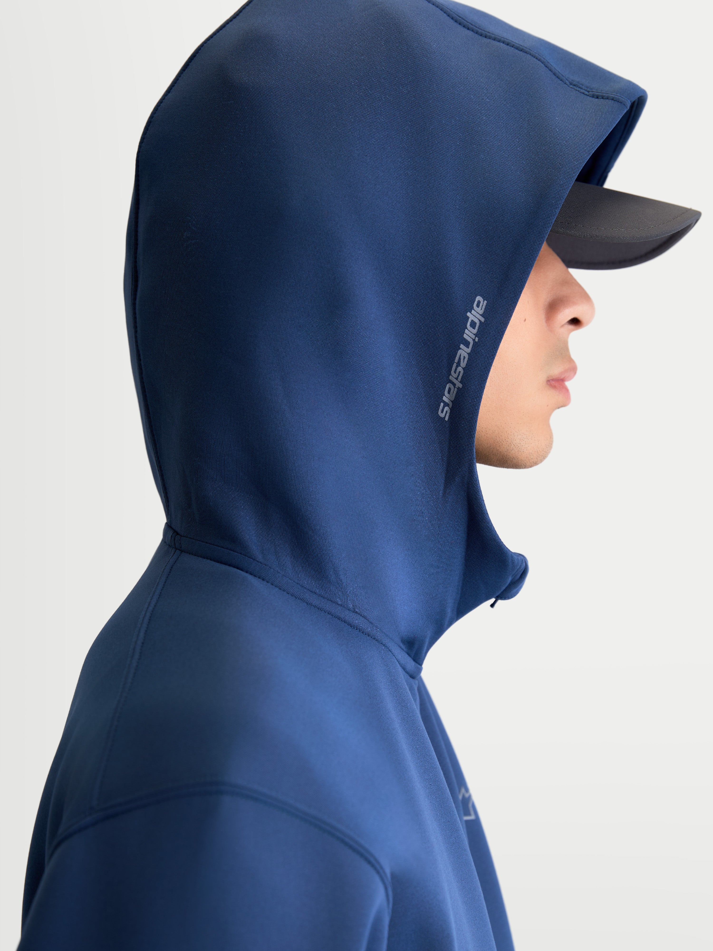 Alpinestars Cypher hættetrøje, motorsport-inspireret sportstøj, blå, unisex fleecehættetrøje med lynlås, højhalset hætte med mesh-for og Alpinestars-logo på siden, set fra siden på model.
