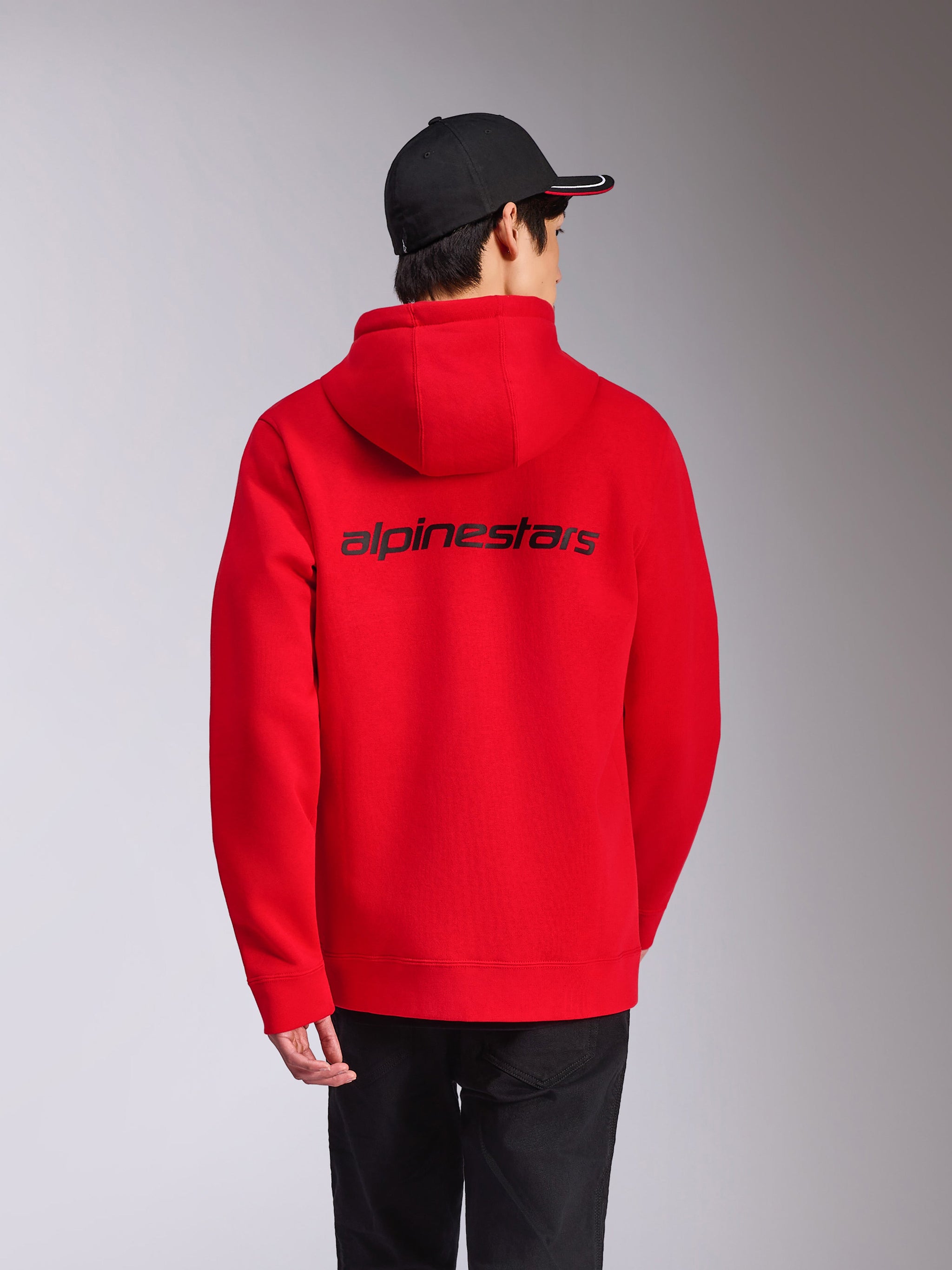 Alpinestars Transverse Hoodie, rød, set bagfra med sort Alpinestars Word-logo på ryggen, afslappet streetwear, fleece-hættetrøje med ribkanter og -søm, stylet med en sort kasket