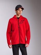 Alpinestars Transverse Hoodie, rød fleece-hættetrøje med lynlås foran, sort Astars-logo på brystet og 'One Goal'-print, afslappet streetwear-stil båret med en sort kasket og bukser