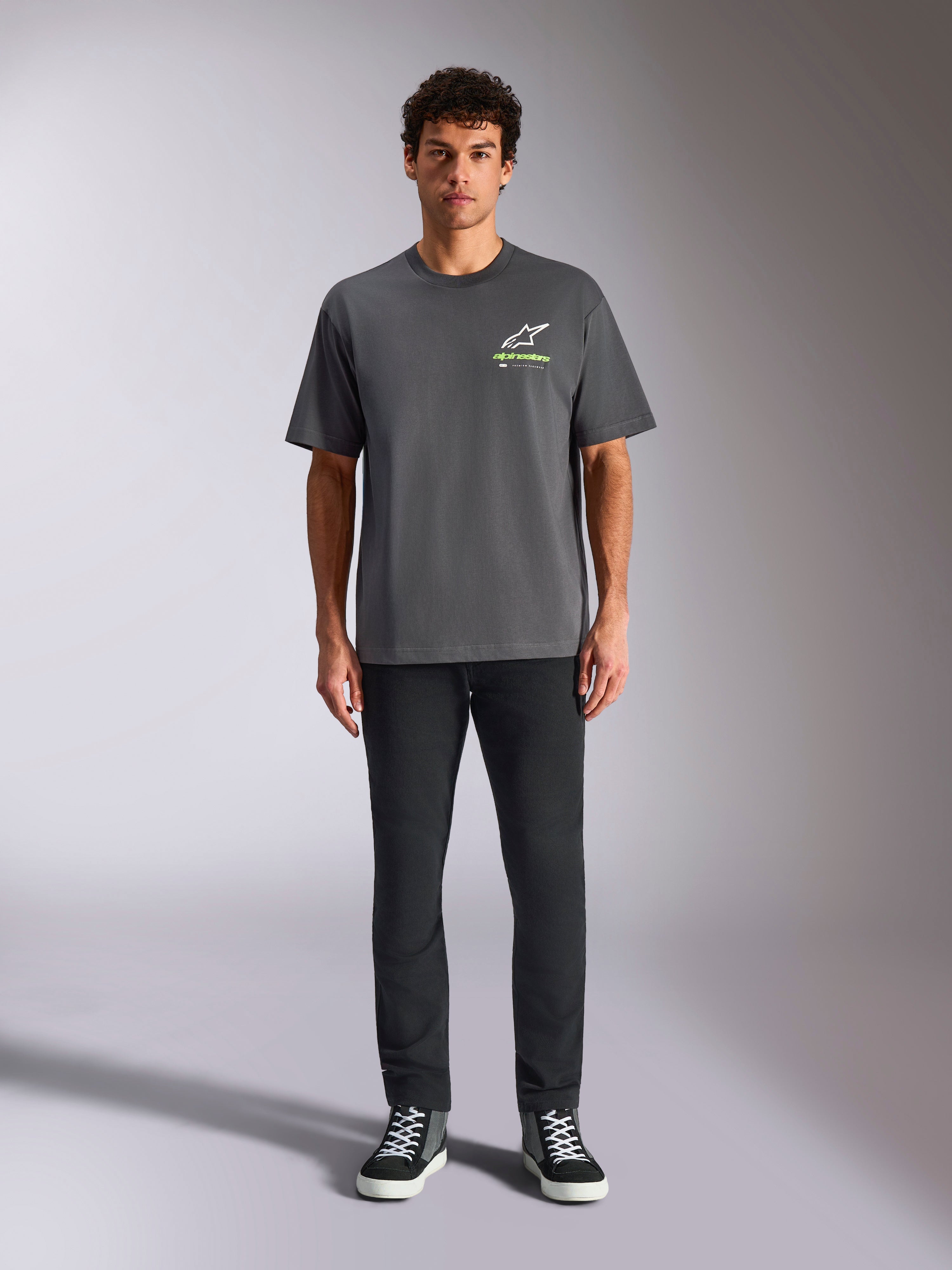 Alpinestars Overhang Oversized CSF Tee, kortærmet T-shirt, koksgrå, med et hvidt og limegrønt Alpinestars-logo på brystet, båret af en model med sorte bukser og sneakers, afslappet casual streetwear