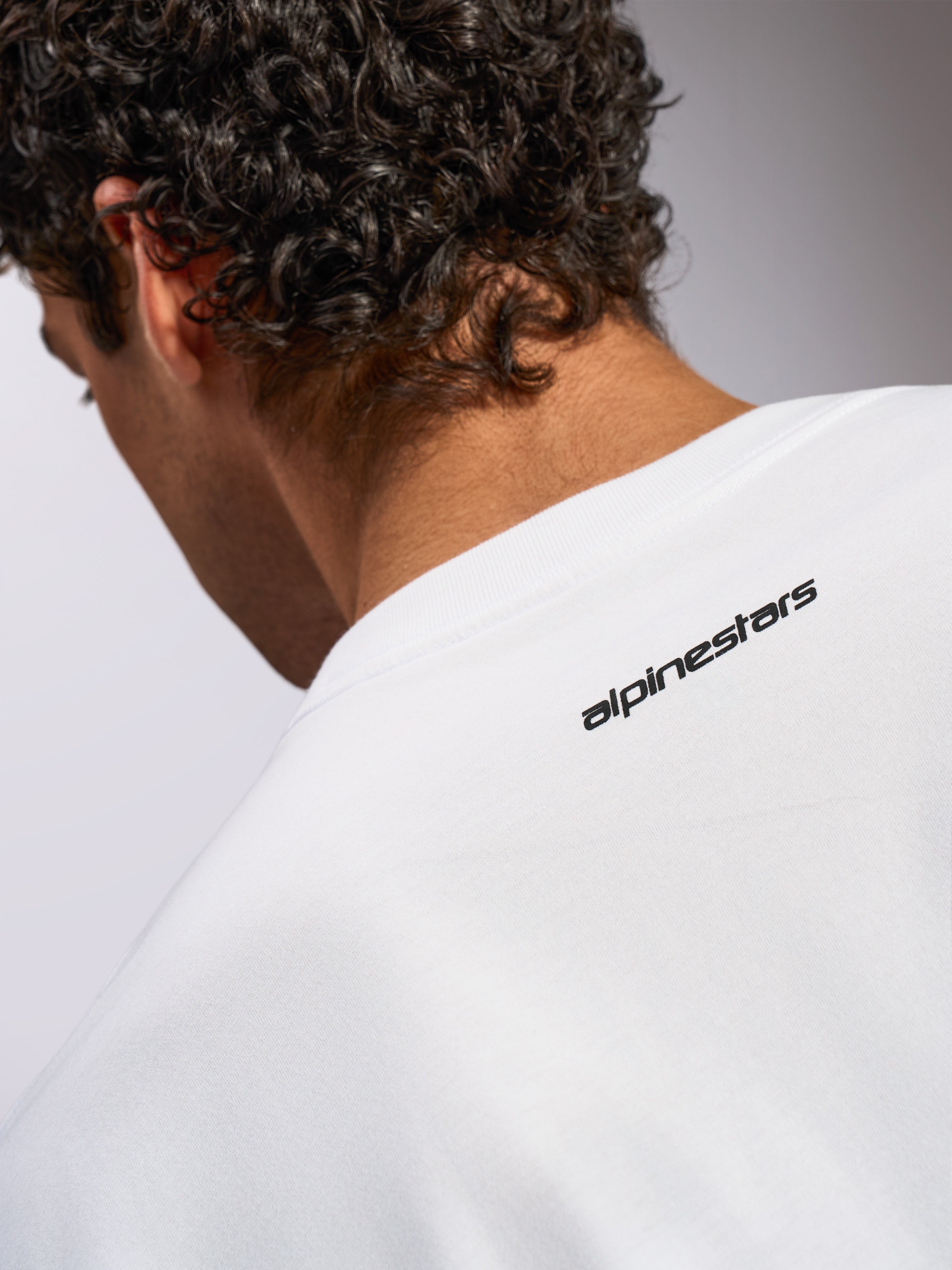 Alpinestars Focused Oversized CSF Tee, kortærmet t-shirt, hvid, nærbillede af nakkeområdet med lille sort Alpinestars-tekstlogo, afslappet motorsport-inspireret design