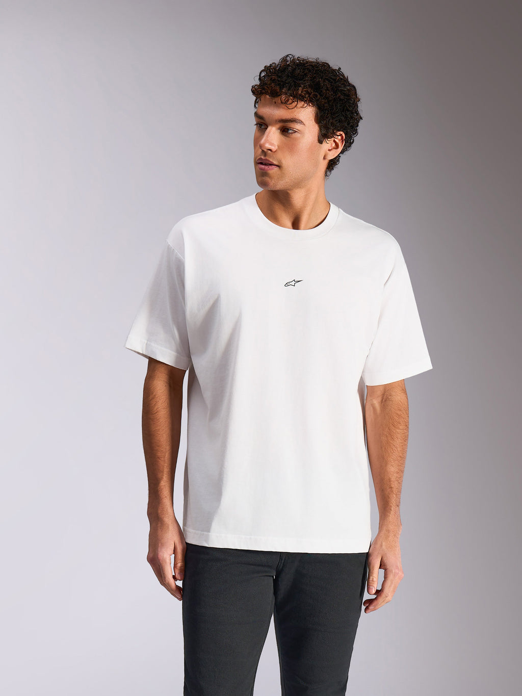 Alpinestars Focused Oversized CSF Tee, kortærmet t-shirt, hvid, lille sort Astars-logo på brystet, løs pasform vist på model, afslappet motorsport-streetwear