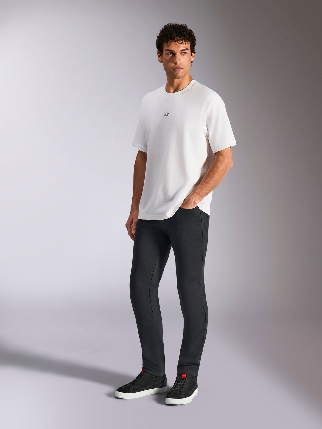 Alpinestars Focused Oversized CSF Tee, kortærmet t-shirt, hvid, med et lille sort Astars-logo på brystet, båret af mandlig model med mørke bukser og sorte sneakers, afslappet motorsport-inspireret streetwear