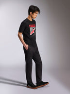 Alpinestars Noka CSF Tee, kortærmet t-shirt, sort, Astars-logo på fronten med rød og hvid MX-graduering, båret med sorte cargobukser og sneakers, afslappet motorsport-inspireret streetwear