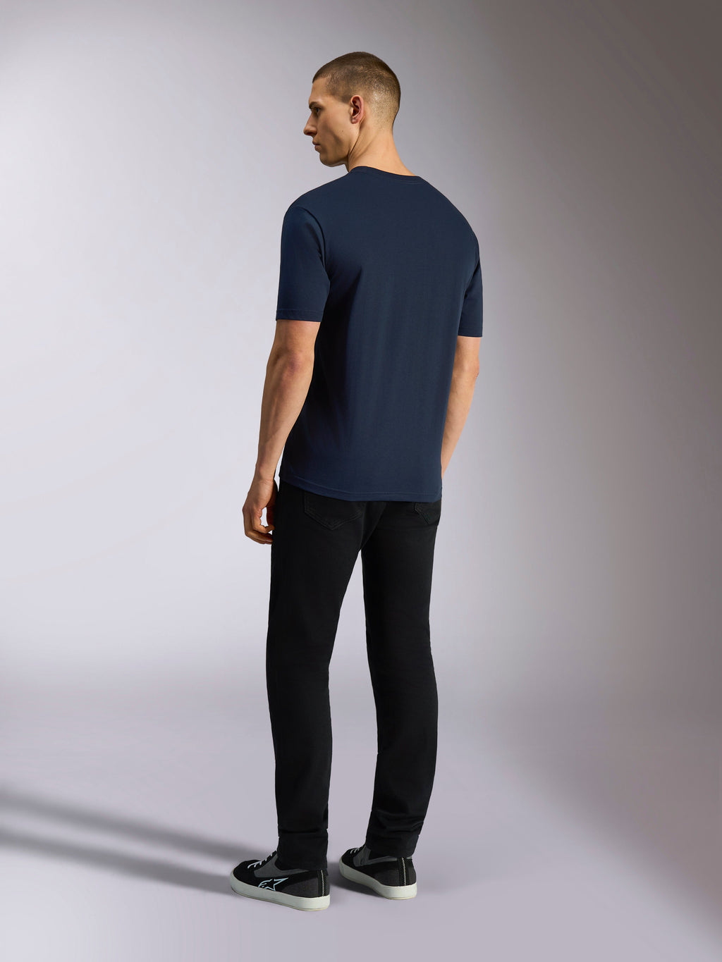 Alpinestars Noka CSF Tee, kortærmet T-shirt, marineblå, set bagfra på model iført sorte bukser og sneakers, casual motorsport streetwear