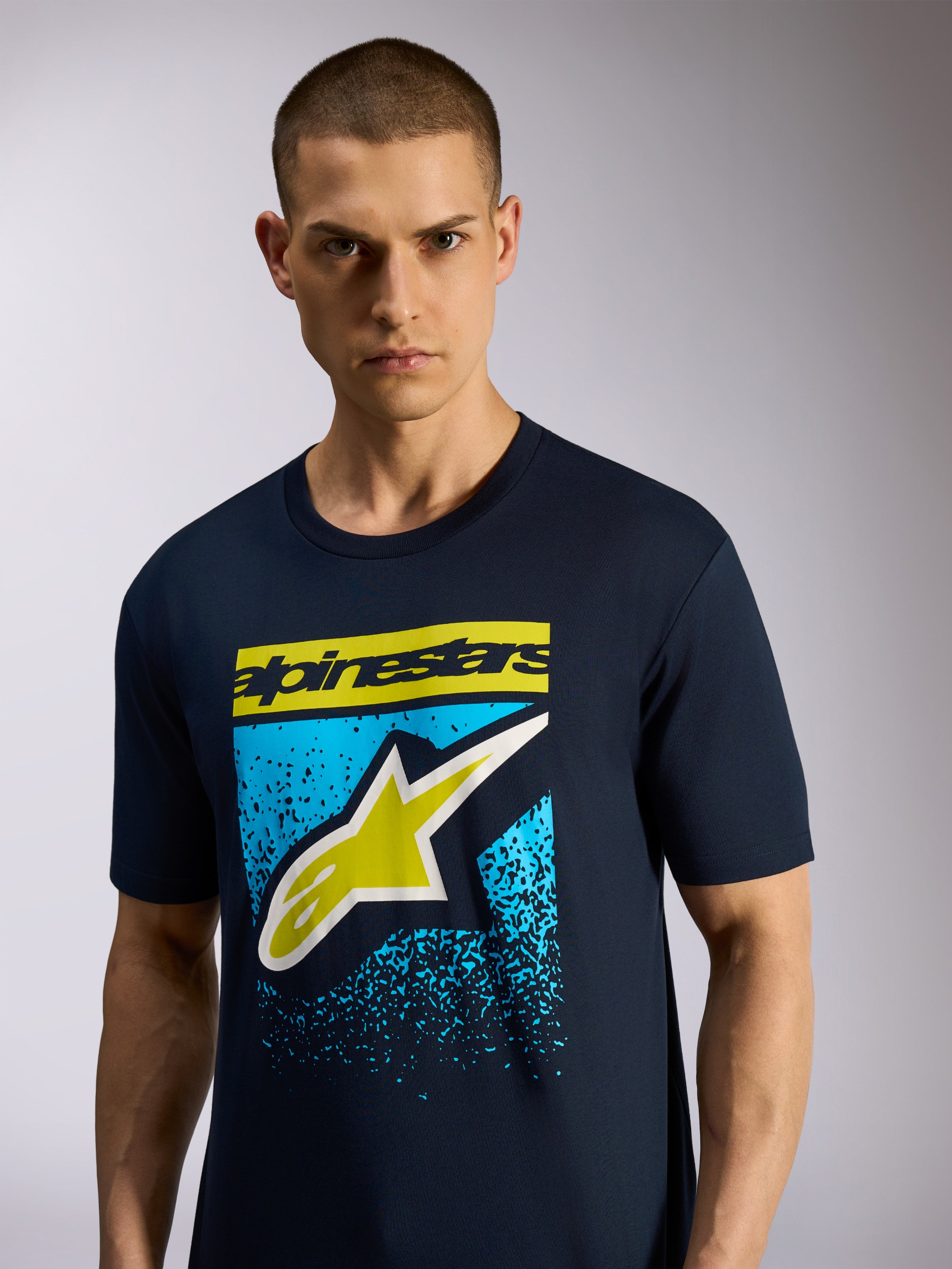 Alpinestars Noka CSF Tee, kortærmet T-shirt, marineblå, med Astars-logo på forsiden, gult tekstlogo og blå nistret grafik, casual motorsport-sportstøj