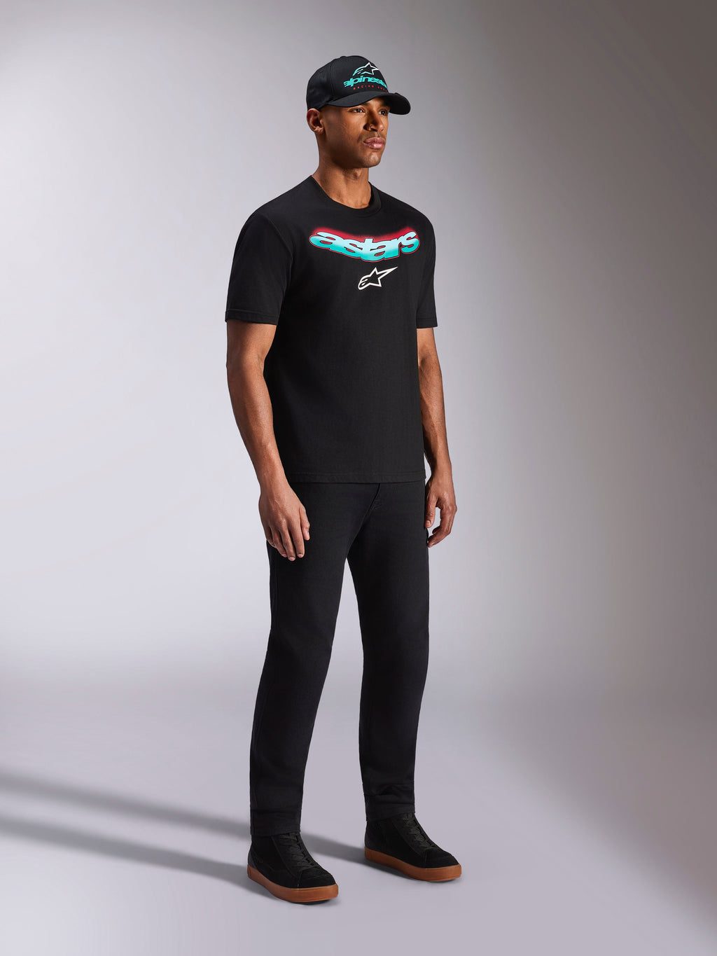 Alpinestars Ellipsoid CSF Tee, sort kortærmet t-shirt, blågrøn og rød gradient Astars-grafik med hvidt logo, mandlig model iført afslappet streetwear med sort kasket og bukser