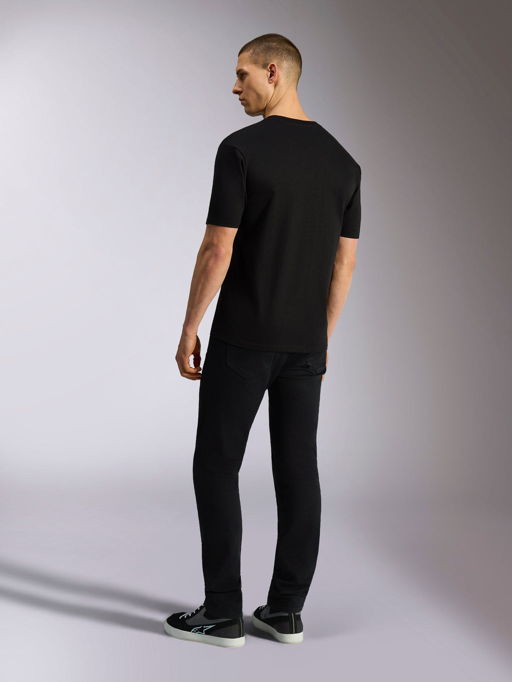 Alpinestars MX CSF Tee, kortærmet t-shirt, sort, set bagfra på en model med sorte bukser, afslappet motorsport streetwear