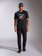 Alpinestars Plate CSF Tee, Short Sleeve T-Shirt, Black, Front MX plate graphic with white Astars logo and blue and red accents, worn by model with matching black cap and pants, casual motorsport sportswear