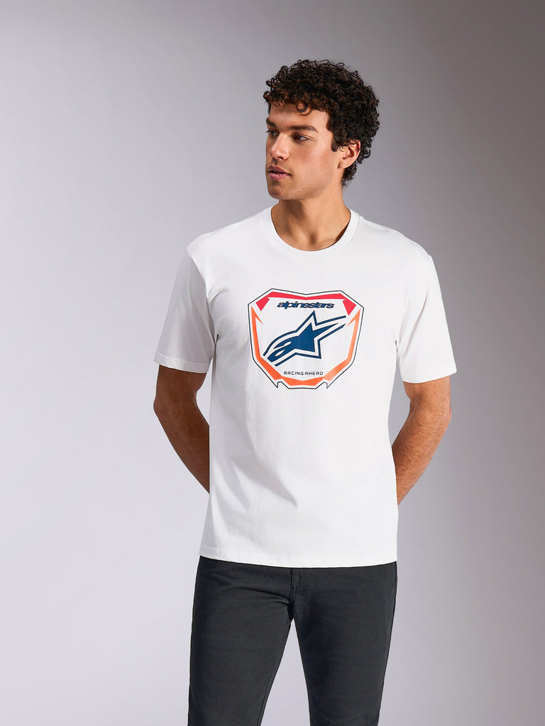 Alpinestars Plate CSF Tee, kortærmet t-shirt, hvid, med Astars MX-plade grafik på fronten, blåt logo og orange kant, bæres af en model, casual motorsport streetwear