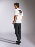Alpinestars Pop Helmet CSF Tee, kortærmet T-shirt, hvid, set bagfra på model med farverig M10 hjelm-grafik, kombineret med mørke bukser og sorte sneakers, afslappet motorsport-inspireret streetwear
