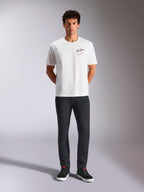Alpinestars Pop Helmet CSF Tee, kortærmet T-shirt, hvid, bæres af en model med sorte bukser og sorte high-top sneakers, Astars-logo på fronten med lyserød 'Alpinestars Protects' tekst, casual motorsport streetwear