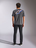 Alpinestars Angler CSF Tee, kortærmet t-shirt, koksgrå, stort flerfarvet Astars-logo på ryggen med røde og blå detaljer, set bagfra på model, afslappet motorsport-streetwear
