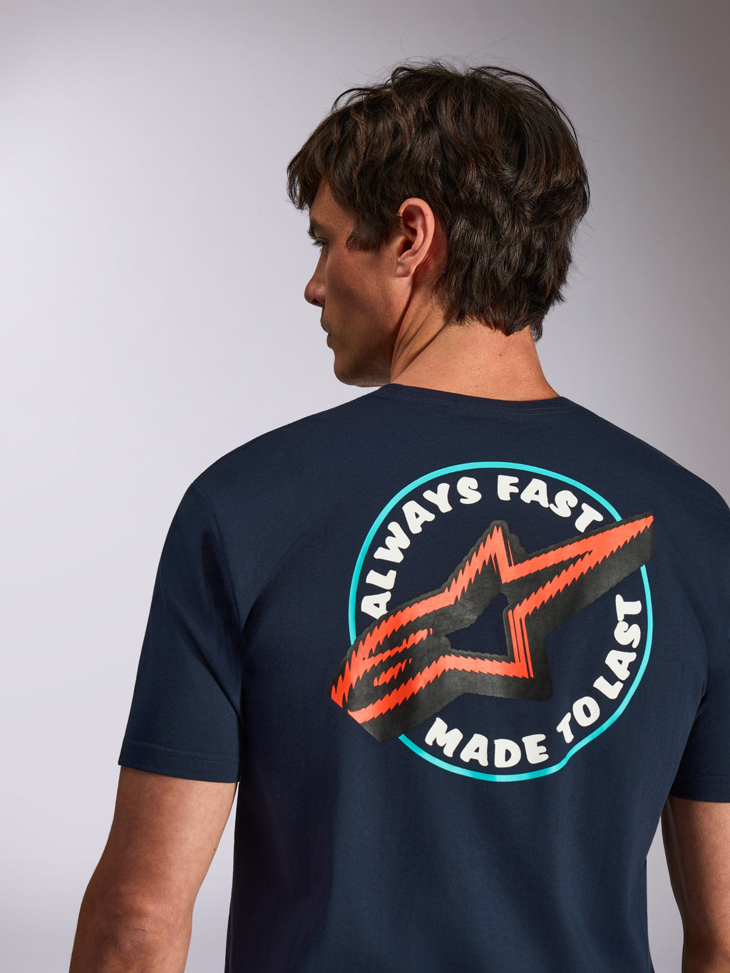 Alpinestars Aorbit CSF Tee, kortærmet t-shirt, navy, set bagfra med Always Fast Made to Last-grafik og orange stjernelogo, afslappet motorsport streetwear