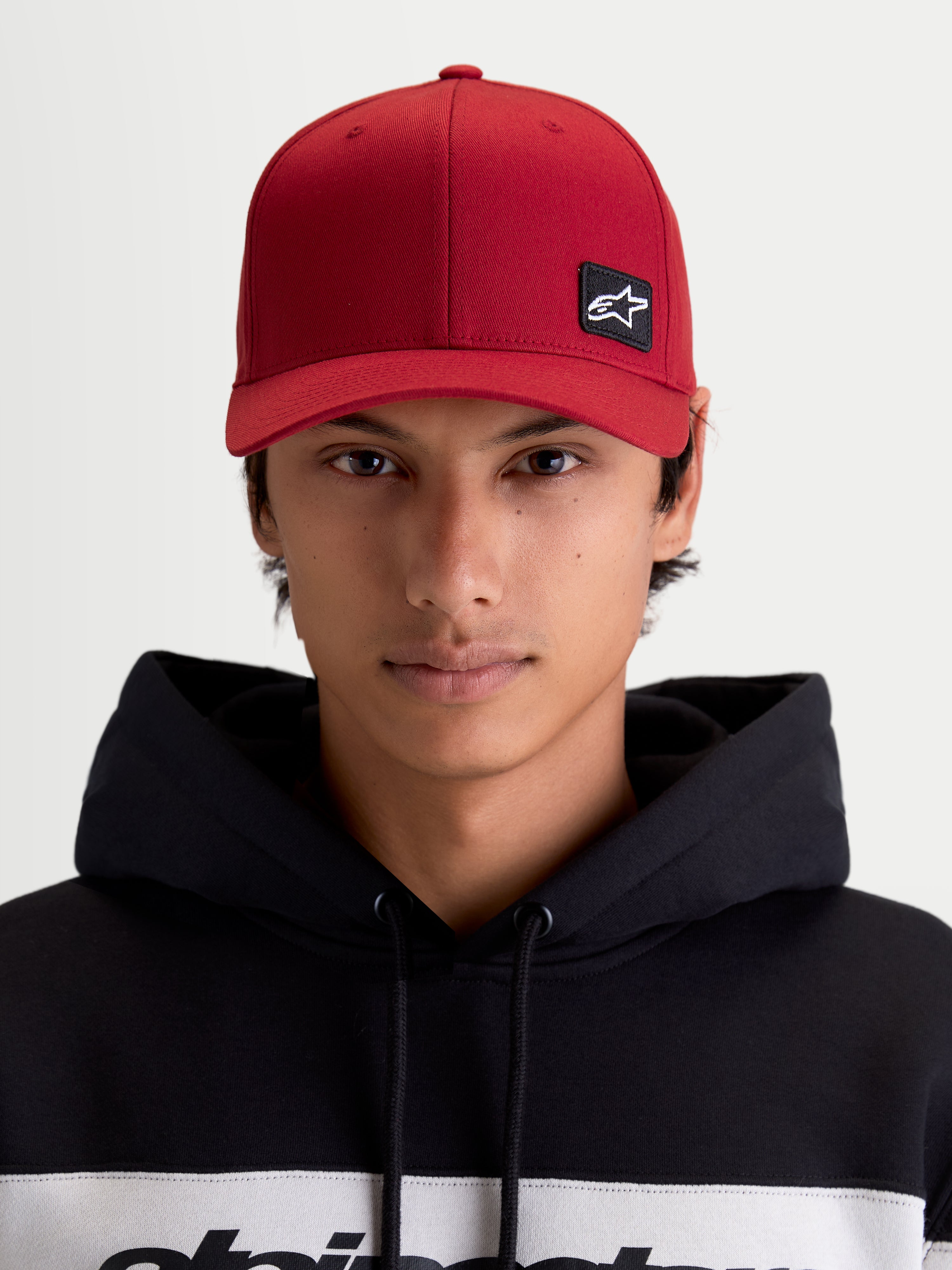 Alpinestars Pivot kasket, mørkerød sportskasket, unisex, set forfra på model med broderet Astars-logo patch, buet skygge, struktureret krone og slidstærk twill-konstruktion.