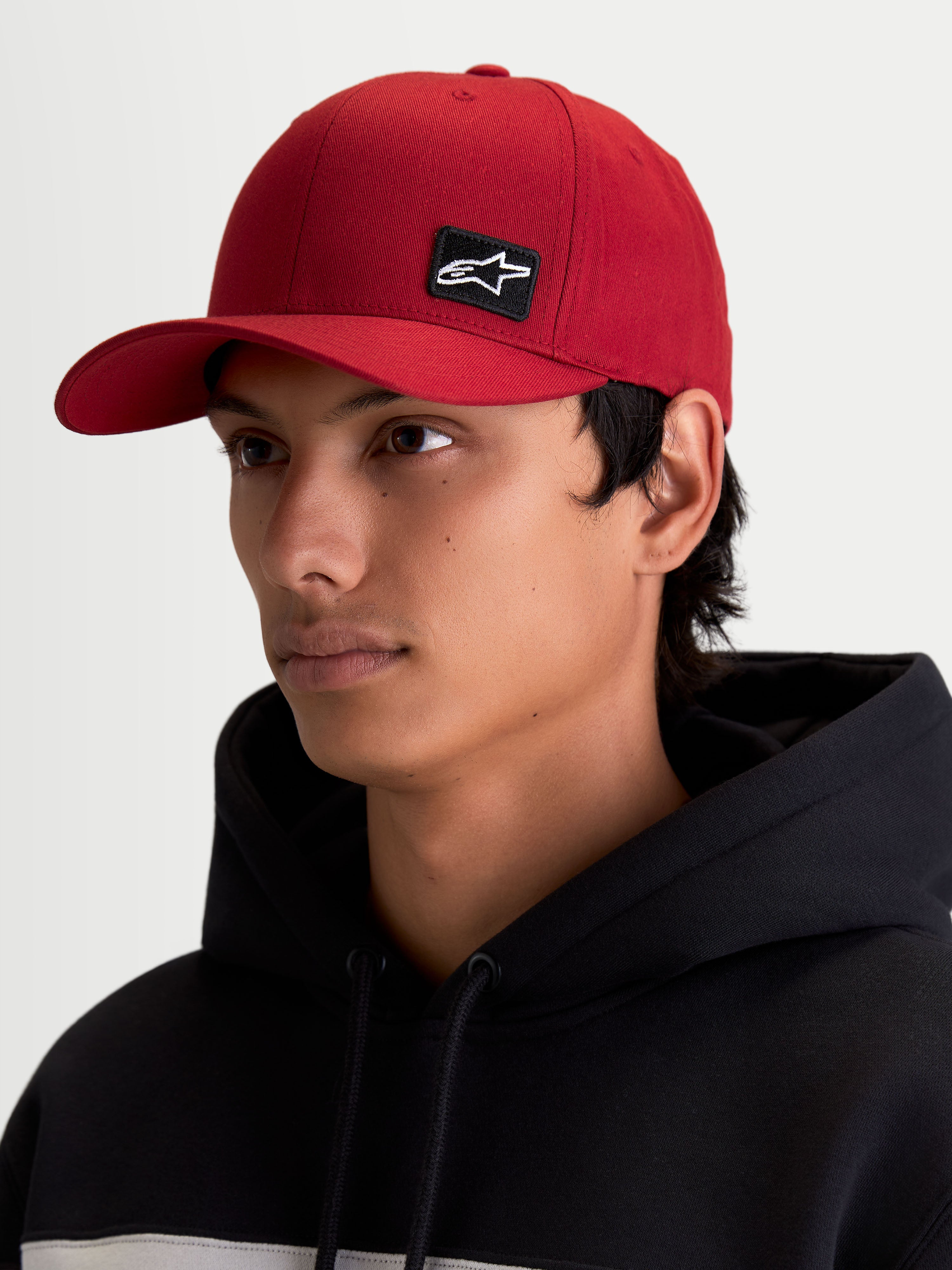 Alpinestars Pivot kasket, mørkerød sportswear kasket med buet skygge og struktureret krone, lille sort broderet Astars-logo på fronten, vist på model, afslappet motorsport lifestyle tilbehør.
