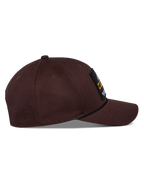Alpinestars Matrix Snapback kasket, mørkebrun, sidevisning med buet skygge, struktureret krone og logomærke på fronten med snore-detalje, afslappet motorsport-inspireret hovedbeklædning
