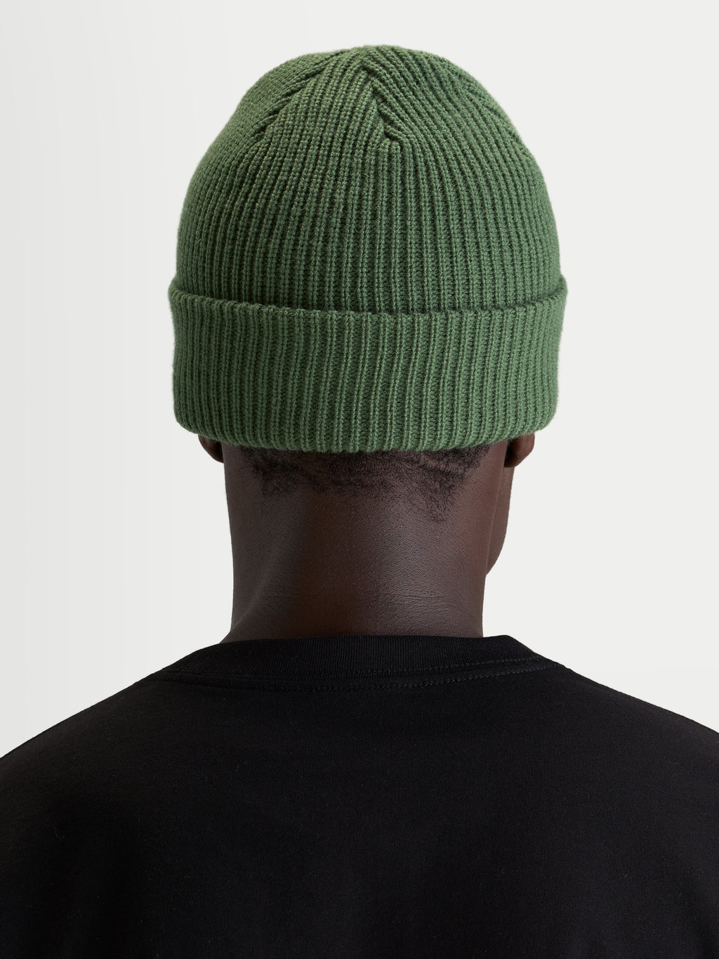 Alpinestars Unload Rib Cuff Beanie, sportswear knit winter hat, pea green, rear view on a model wearing a black t-shirt, showing acrylic jersey stitch construction and classic shallow fit.