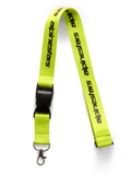 Alpinestars Linear nøglesnor, high vis-gul med sort trykt logo, sort sikkerhedsspænde i plast og drejeklip i metal, 51 cm polyesterrem, motorsport-inspireret tilbehør