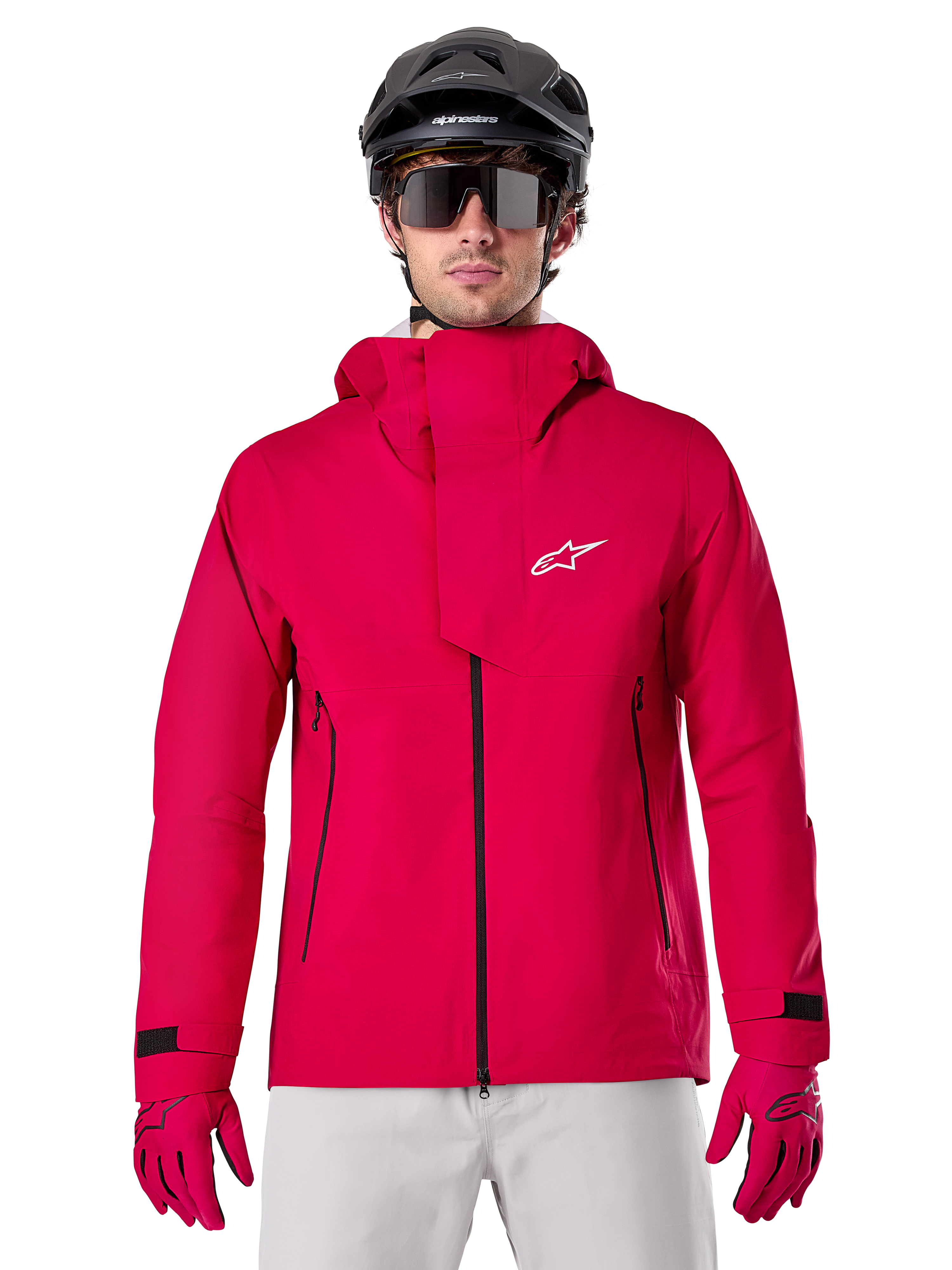 Alpinestars A-Dura Elite vandtæt jakke, MTB-regnjakke, Red Fluo, høj krave med hvidt Alpinestars logo, sorte lynlåsdetaljer, bæres med matchende handsker og sort cykelhjelm, teknisk vandtæt cykeludstyr