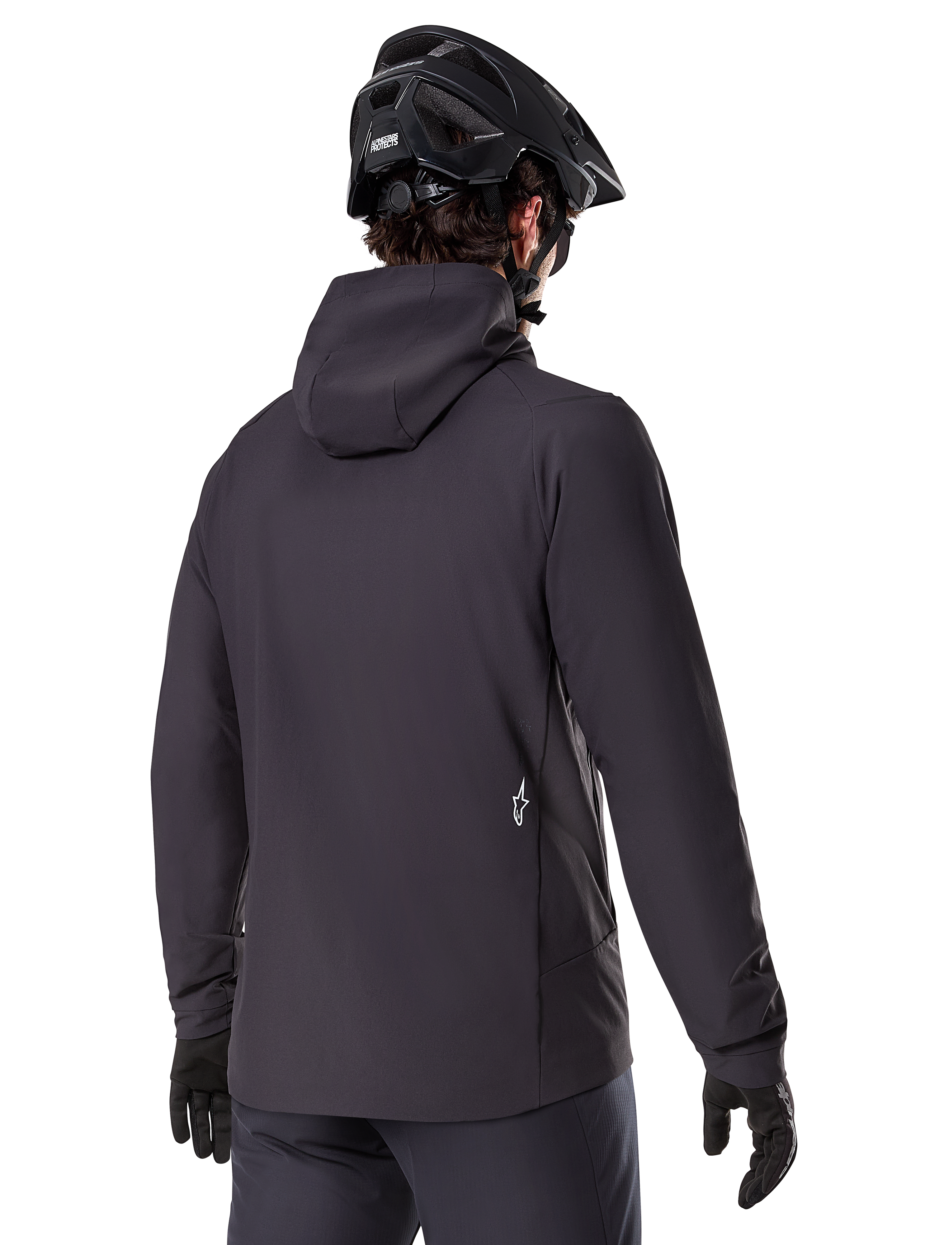 Alpinestars A-Dura Thermal Jacket, sort, set bagfra, båret med en sort mountainbikehjelm og handsker, har et lille hvidt Astars-logo nederst på ryggen, letvægts isoleret cykeljakke