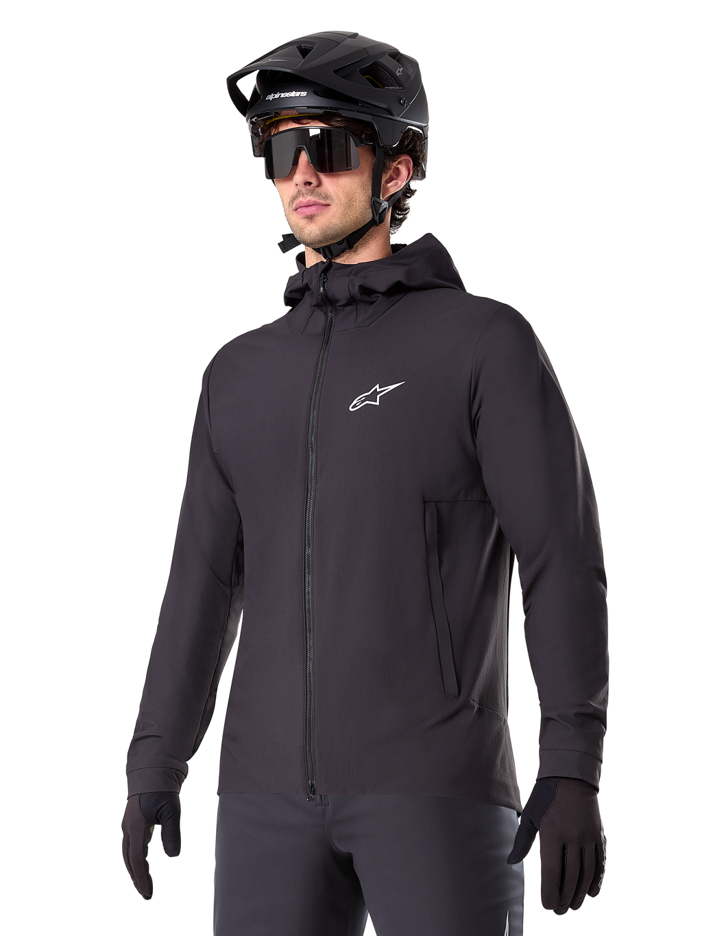 Alpinestars A-Dura Thermal Jacket, sort cykeljakke, design med hætte og lynlås foran, hvidt stjernelogo på brystet, vist med sort mountainbikehjelm og handsker, sporty performance-udstyr til terrænkørsel i koldt vejr