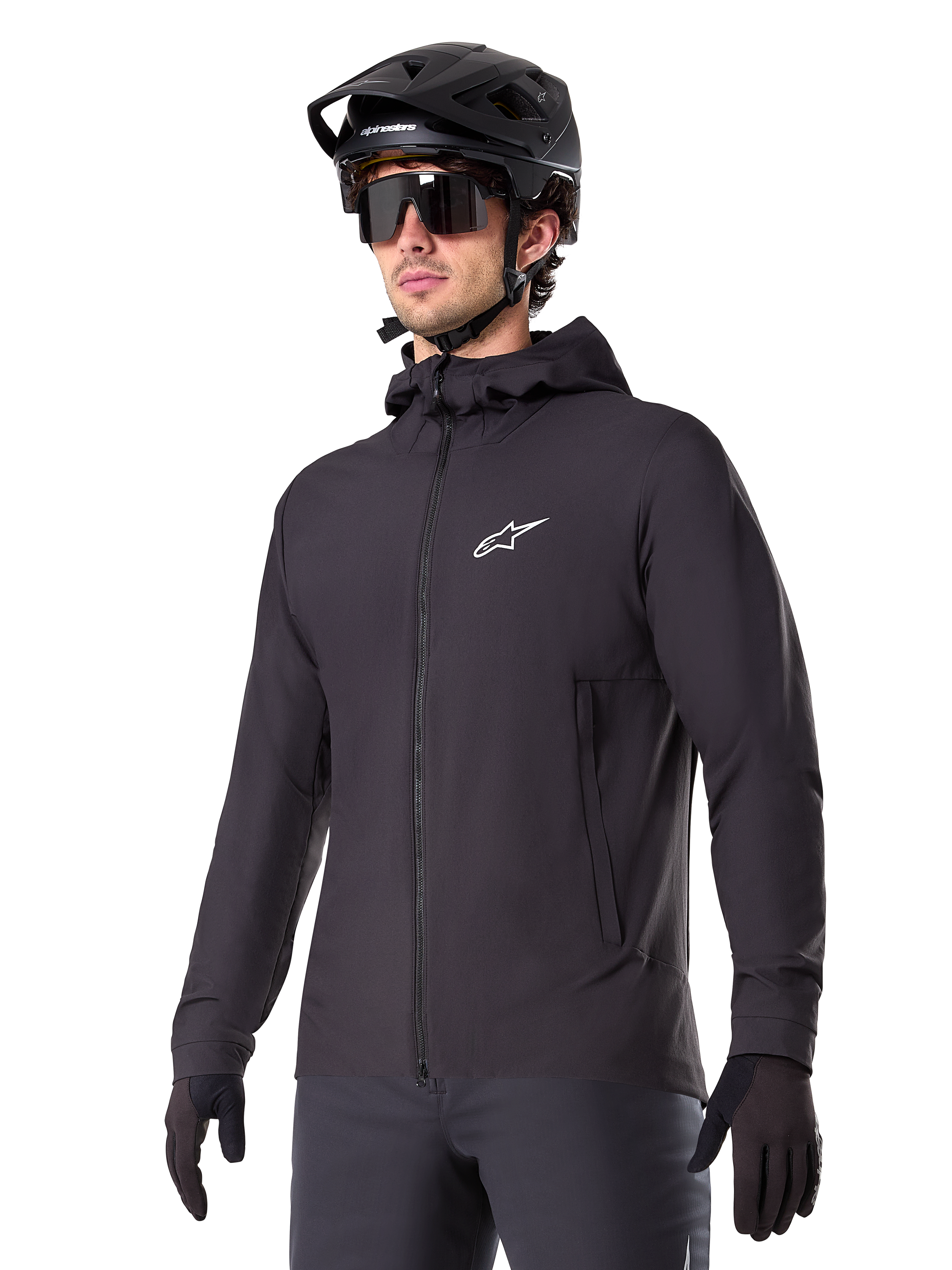 Alpinestars A-Dura Thermal Jacket, sort cykeljakke, design med hætte og lynlås foran, hvidt stjernelogo på brystet, vist med sort mountainbikehjelm og handsker, sporty performance-udstyr til terrænkørsel i koldt vejr