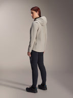Alpinestars Stella A-Dura Thermal Jacket i Titanium Gray, trekvart visning bagfra af en kvinde iført den isolerede cykeljakke med hætte og sorte MTB-bukser, studiebillede der viser den regulære pasform og lommedetaljer.
